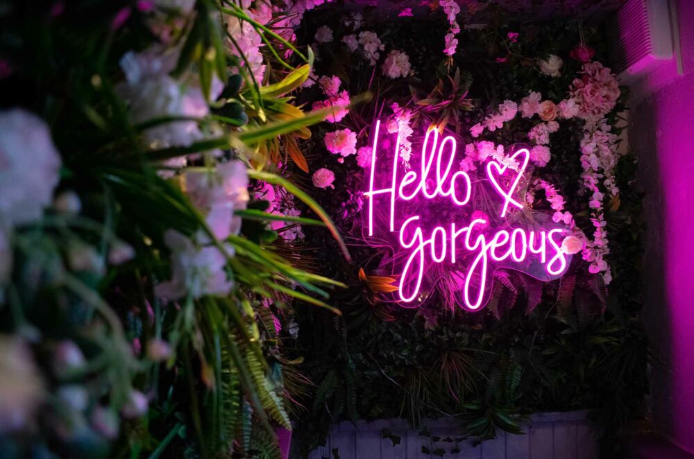 Hello Gorgeous LED neon sign, shown in Hot Pink on clear acrylic backing